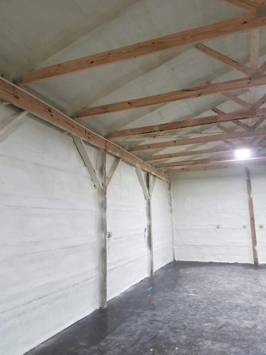 Spray foam insulated walls in a garage with exposed roof trusses