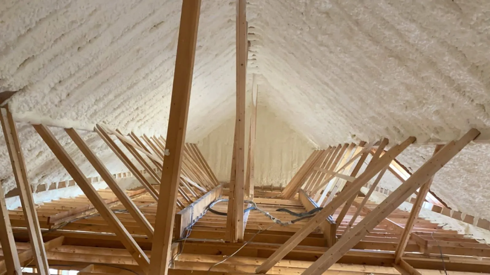 Spray foam insulation on an attic roof deck between trusses